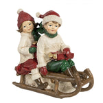 Piros sapkás gyerekek szánon karácsonyi dekoráció